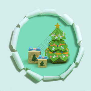 纸圣诞树和礼品盒在带孔的撕纸上体积手工纸对象纸艺和工艺时髦的爱好最小图片