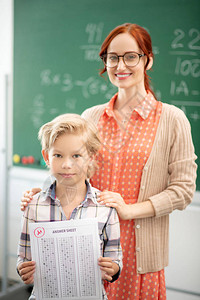 有学生的老师戴眼镜的老师拥抱她聪明的金发学图片