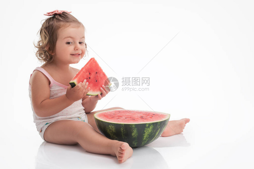 婴儿女孩吃西瓜切片孤图片