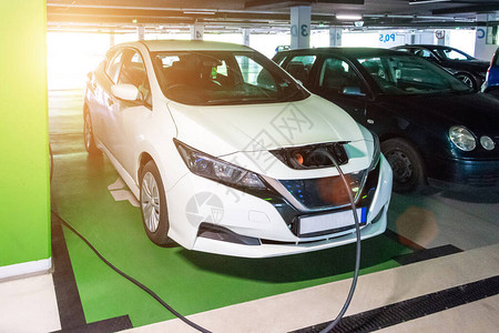 驾驶混合动力车混合动力汽车未来的绿色技术电动汽车在生态能源充电站充电图片