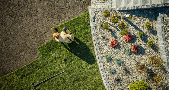 园林绿化和园艺在新开发的住宅花园中安装全新草的园丁鸟瞰图片