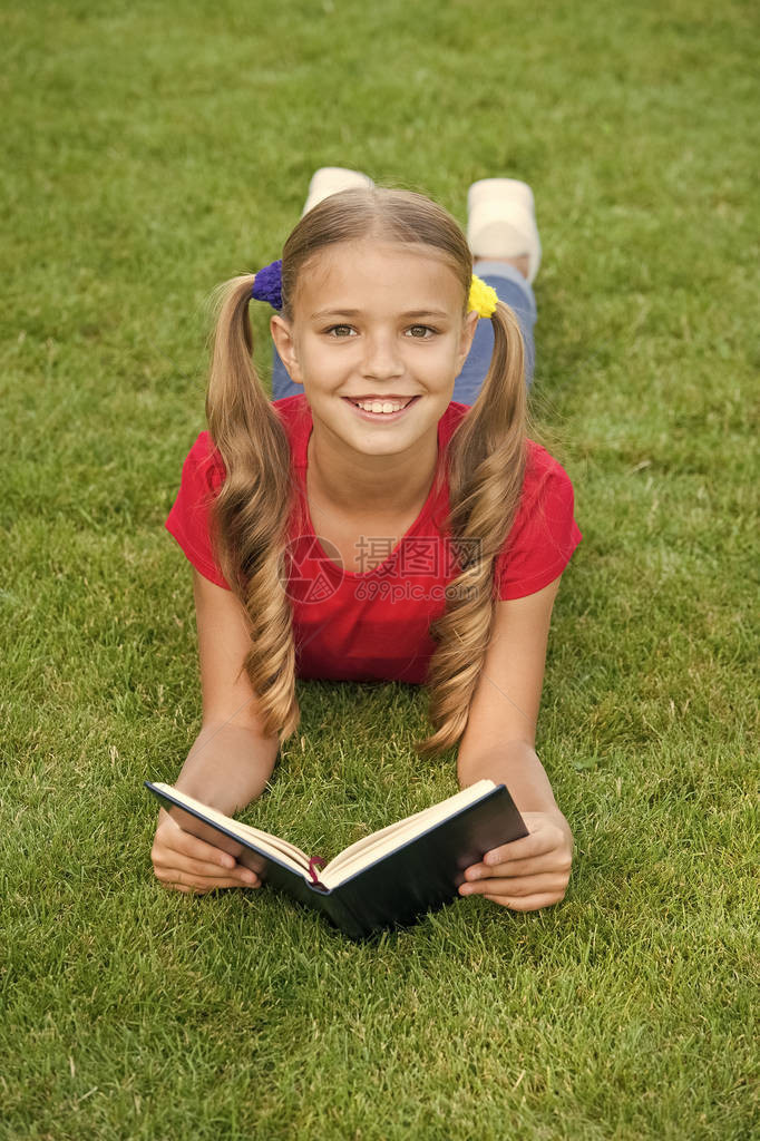 上学时间适合孩子们的有趣故事愉快地学习是时候讲好故事了小孩在户外看书女学生一边放松绿色草坪一边读故事可爱的图片