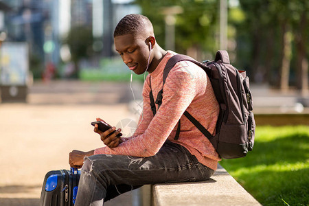 年轻黑人旅行男子的肖像他们用手机和图片