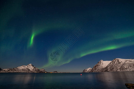 美丽的北极光绿色的北极光星空与极光冬季景观与极光海与天空反射和雪山图片