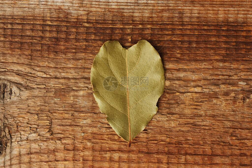 木制背景上的心形月桂叶图片