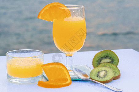 美味早餐橙汁和片带种子的绿色千维菜背景图片