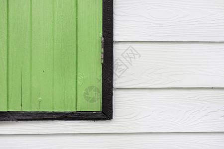 房子里白色木墙上的绿色木窗的一角图片