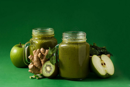 绿色背景的罐子里的健康绿色冰沙图片