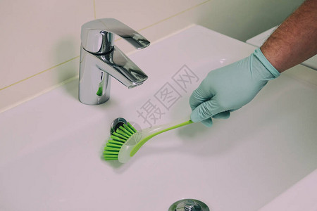手戴橡胶保护手套的男用刷子是洗手间清洁管道家务活清图片