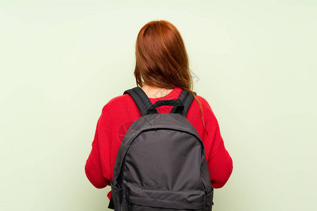 穿着毛衣的青少年红发女孩带着背包和图片