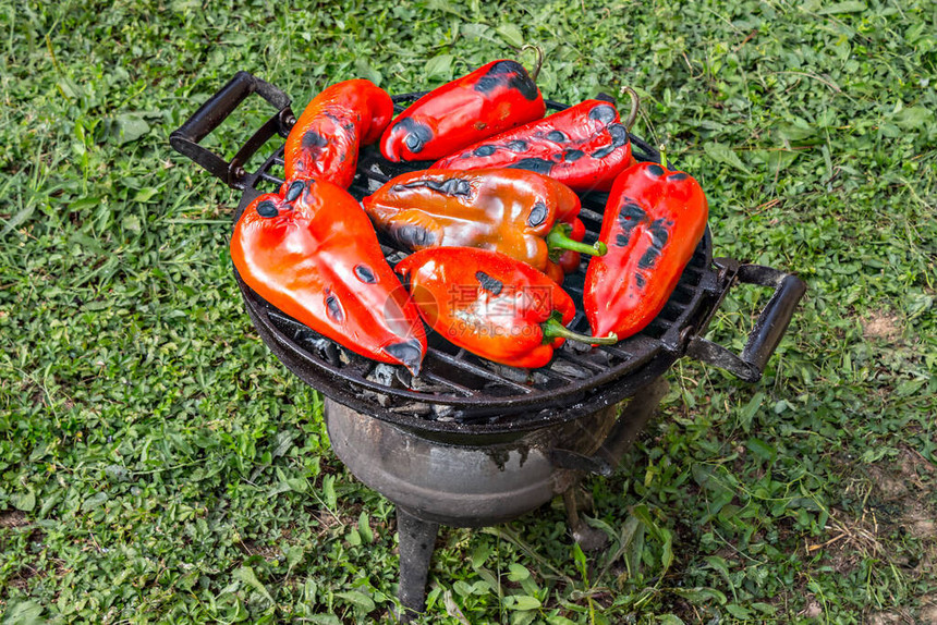 烤锅上新鲜的红辣椒在后院图片