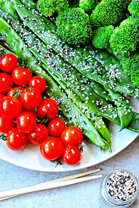 盘子上的健康食品青豆西兰花樱桃番茄有用的绿色蔬菜沙拉配烤樱桃番茄和芝图片