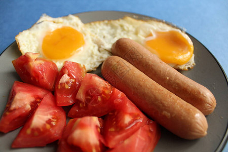 传统欧洲早餐鸡蛋香肠和沙拉蔬菜红西番茄图片