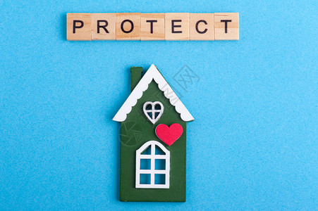 绿色木屋和保护标志在蓝色背景与复制空间安全或检疫概念家庭保护房地产保图片