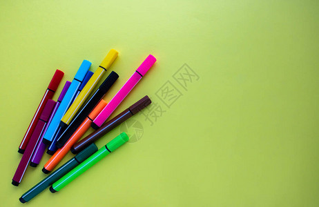 彩色厚标记红色黄绿粉红色蓝紫位于黄色背景上彩虹色的办公用品图片