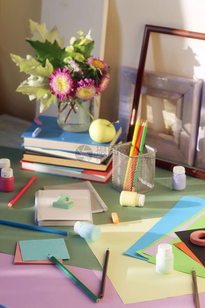 桌子上的书花苹果文具框架和彩纸图片