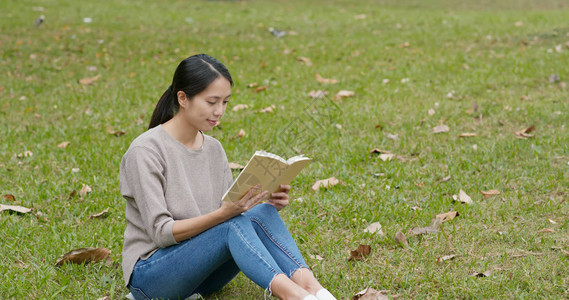 女人读书坐在绿草上图片