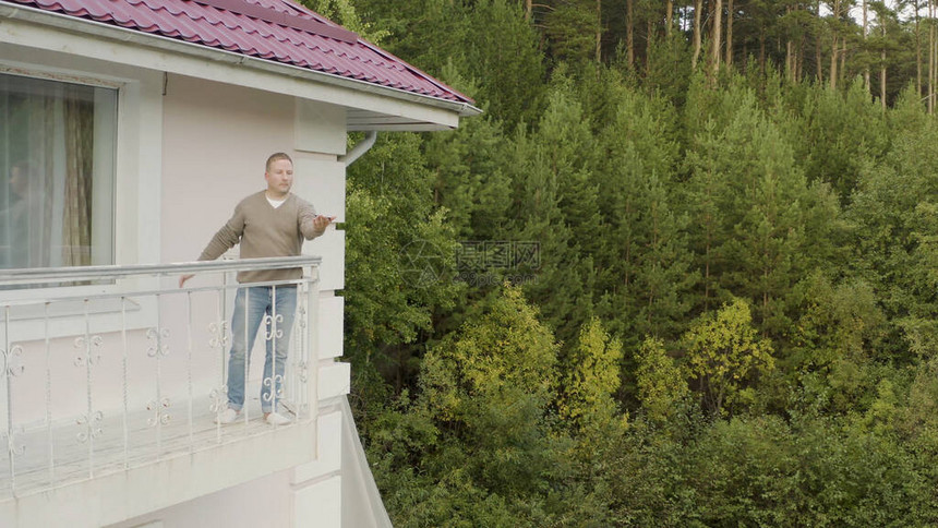 人从手中释放蝴蝶视频站在阳台上的人正试图在森林的背景下将蝴蝶释放到自由中从手中图片