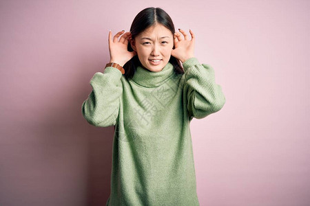 年轻漂亮的亚洲女人穿着绿色的冬装图片