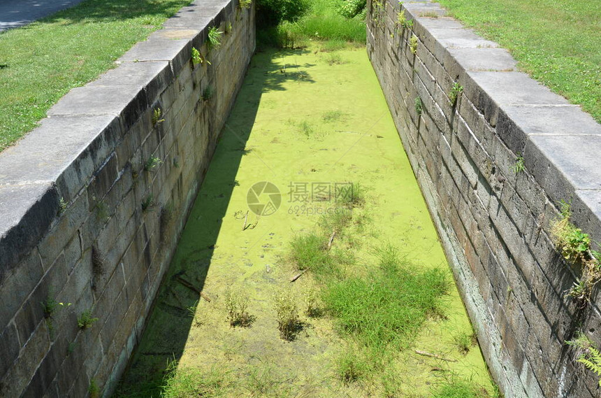 有石墙和绿藻和水的老运河图片