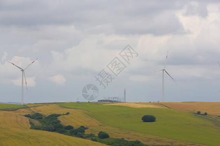 Wildmill站在蓝天山的田野上背景图片