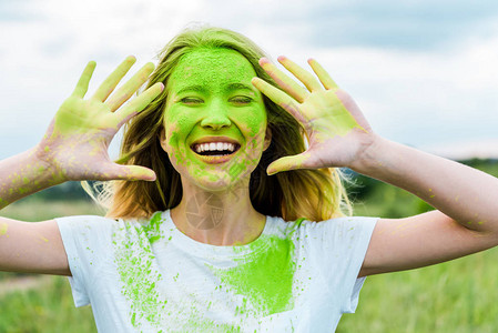 眼闭的开心女人双手沾满绿色胡利涂鸦露着微笑图片