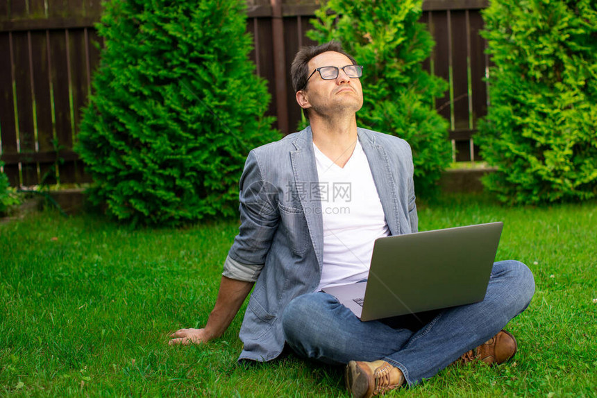 冷静而平衡的商人盘腿坐在草地上图片