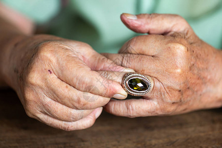 老人戴着左手无名指的珠宝戒指图片