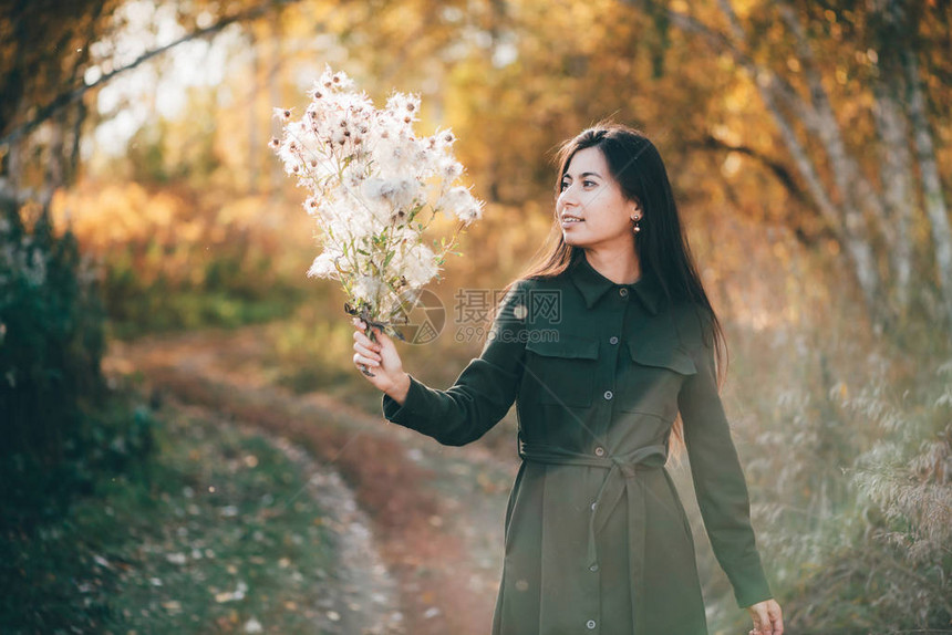 梦幻的美丽女孩带着金花束在金光下图片