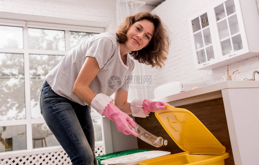 年轻女孩在厨房分拣垃圾回收的概念图片