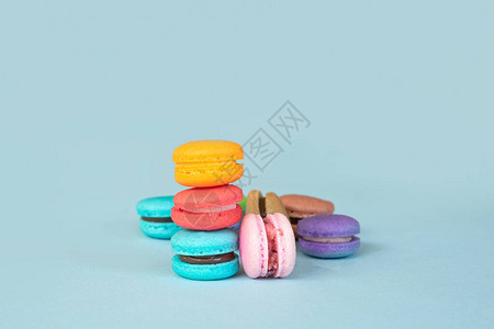 蓝色背景上的彩色马卡龙甜点图片