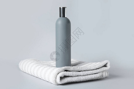 灰色背景的洗发水和毛巾图片