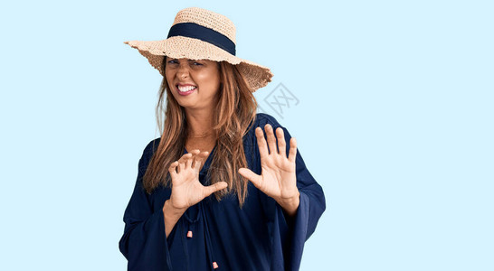 身戴夏帽的中年女西班牙裔女因反感而到厌恶不高兴和恐惧地面对厌恶图片