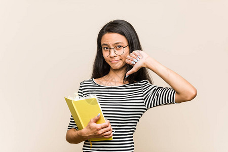 年轻的亚洲女学生拿着一本书图片