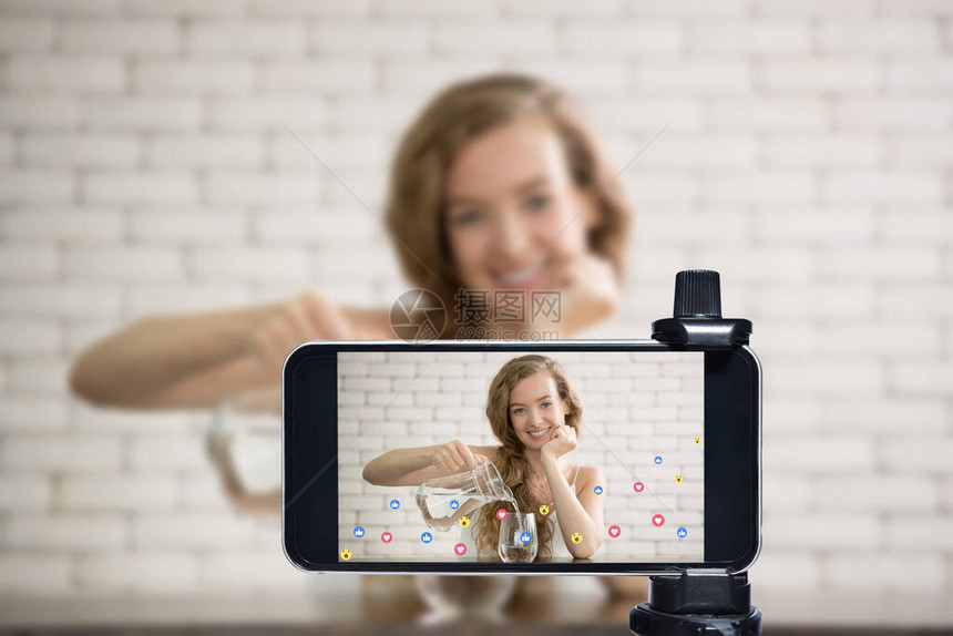 年轻女博主视频博主和在线影响者使用智能手机在社交媒体上直播健图片
