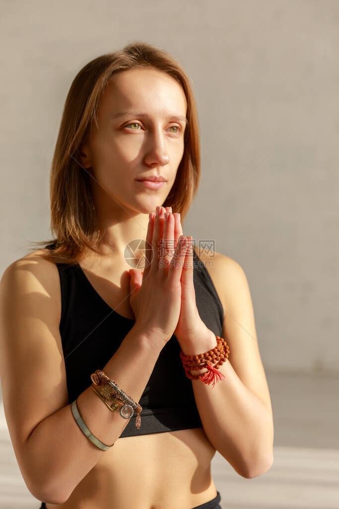 美丽的女人双手祈祷在瑜伽室冥想图片