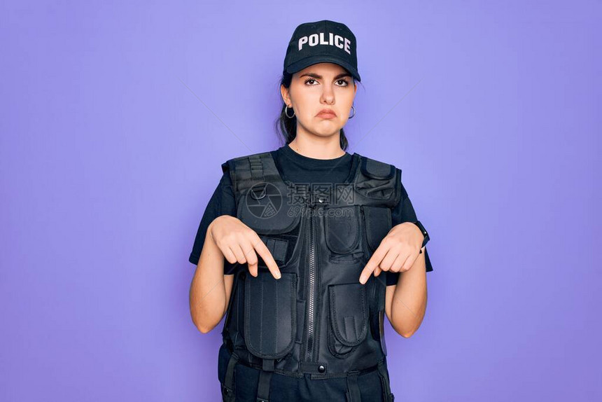身穿紫色背景安全防弹背心制服的年轻女警察指着下方图片