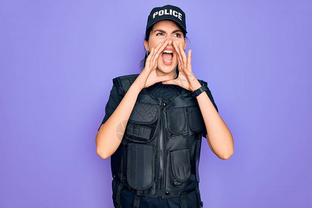 身穿紫色背景安全防弹背心制服的年轻女警用手捂图片