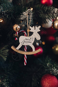 装饰木鹿的特写镜头与文本圣诞快乐挂在美丽的绿色圣诞树上圣诞节图片