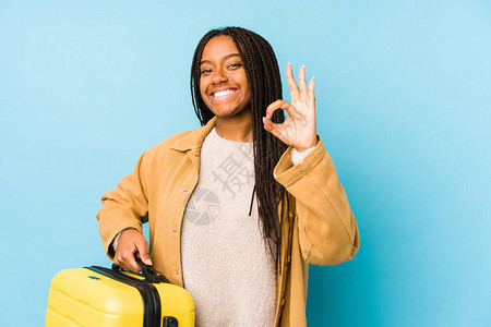 带着手提箱的年轻非洲旅行家女士孤立了快乐和自信地表现出正确的姿态图片