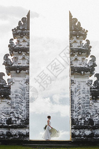 穿着白裙子的女人在普拉兰普阳传统的巴林斯庙门上高清图片