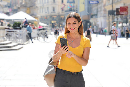 在维也纳Graben街行走的美丽微笑着容的女人用背景图片