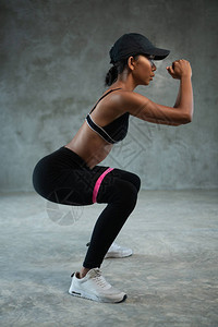 健康美丽的女人在健身房用阻力带锻炼女运动员为下半身的肌肉图片