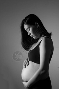 孕妇站着抱着她的肚子怀孕图片