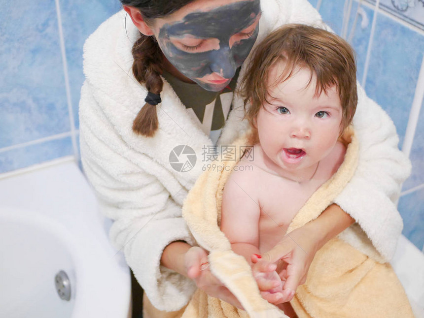 母亲把婴儿放在浴室的毛巾里