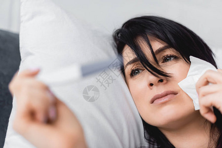 有选择地关注不高兴的妇女在床上看孕检结果为负结果图片