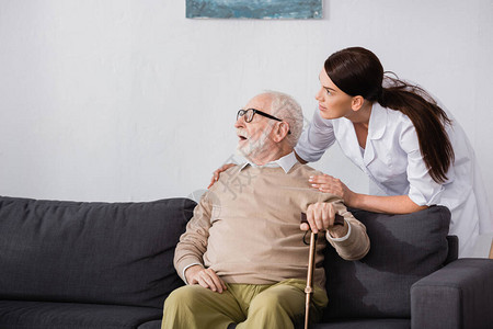 老年男子在坐社会工作者附近的沙发图片
