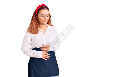 身着女服务员围裙的年轻拉廷妇女因为消化不良痛苦病痛不适而胃疼图片