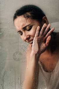 孤独的忧郁的女人在淋浴中哭泣在图片
