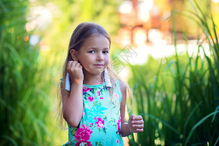 长白耳环的女孩在高草地上自然形成图片